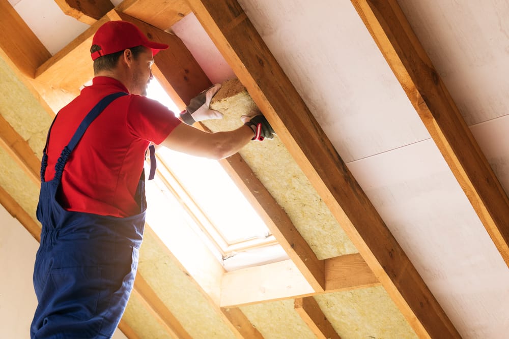 Technician inspecting attic insulation for quality