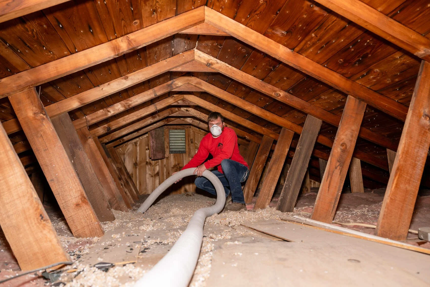 Technician checking attic insulation and airflow for energy efficiency.
