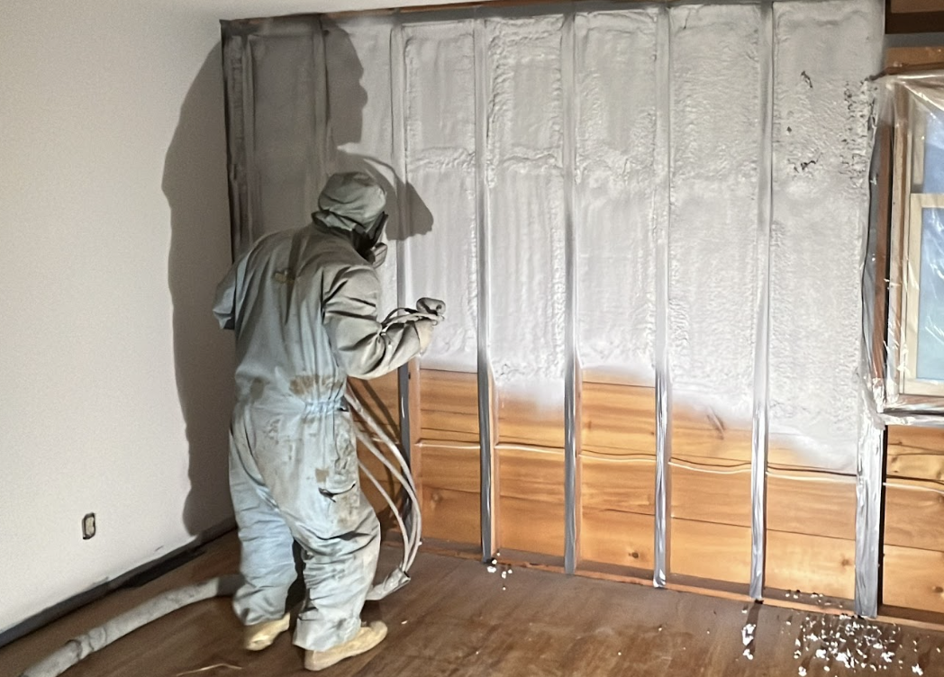 Spray foam insulation being applied in an attic.