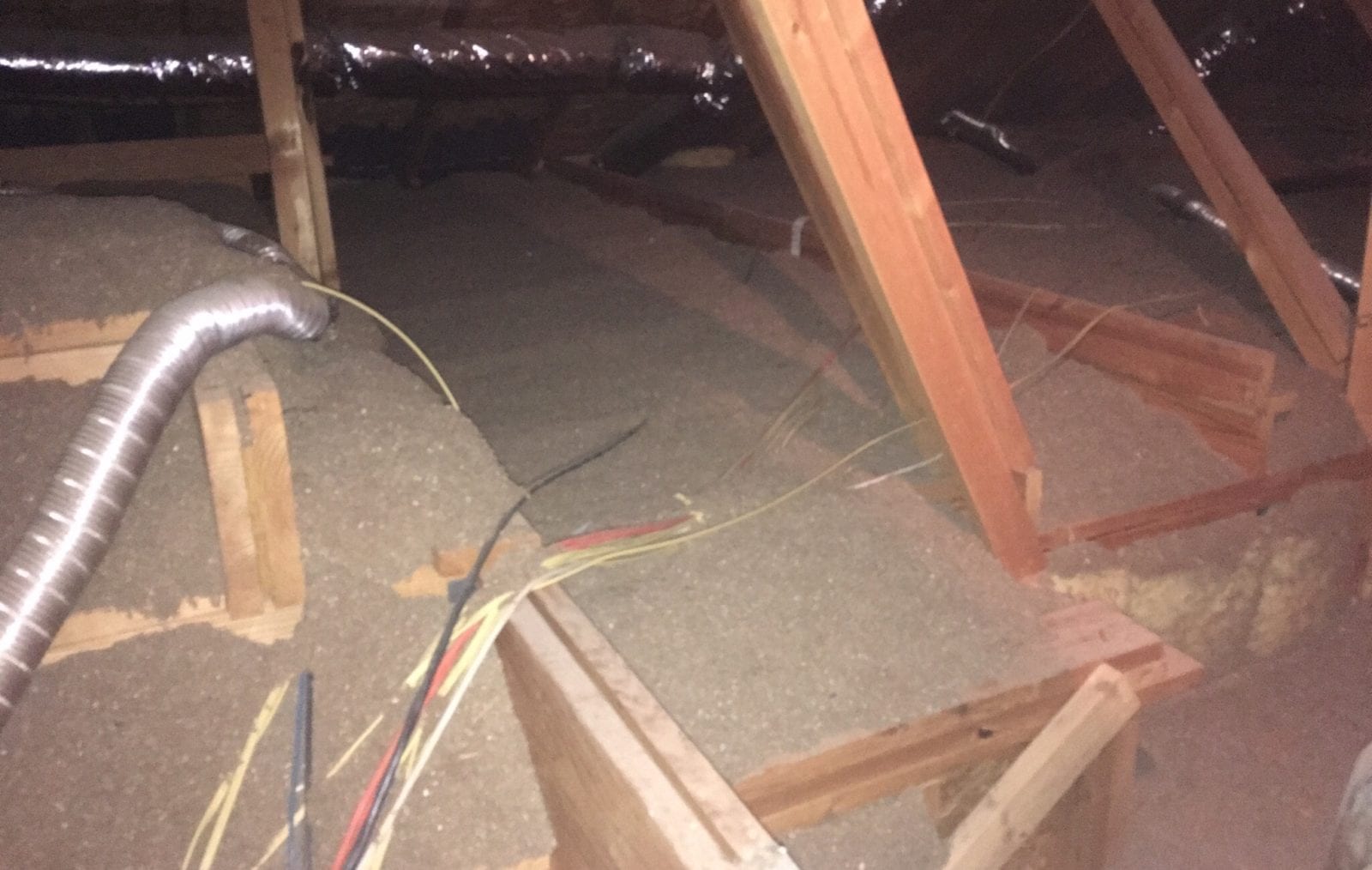 Spray foam insulation being applied in an attic.