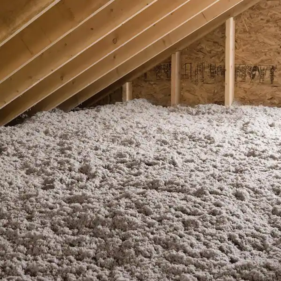 Blown-in insulation covering attic floor and filling gaps between joists.