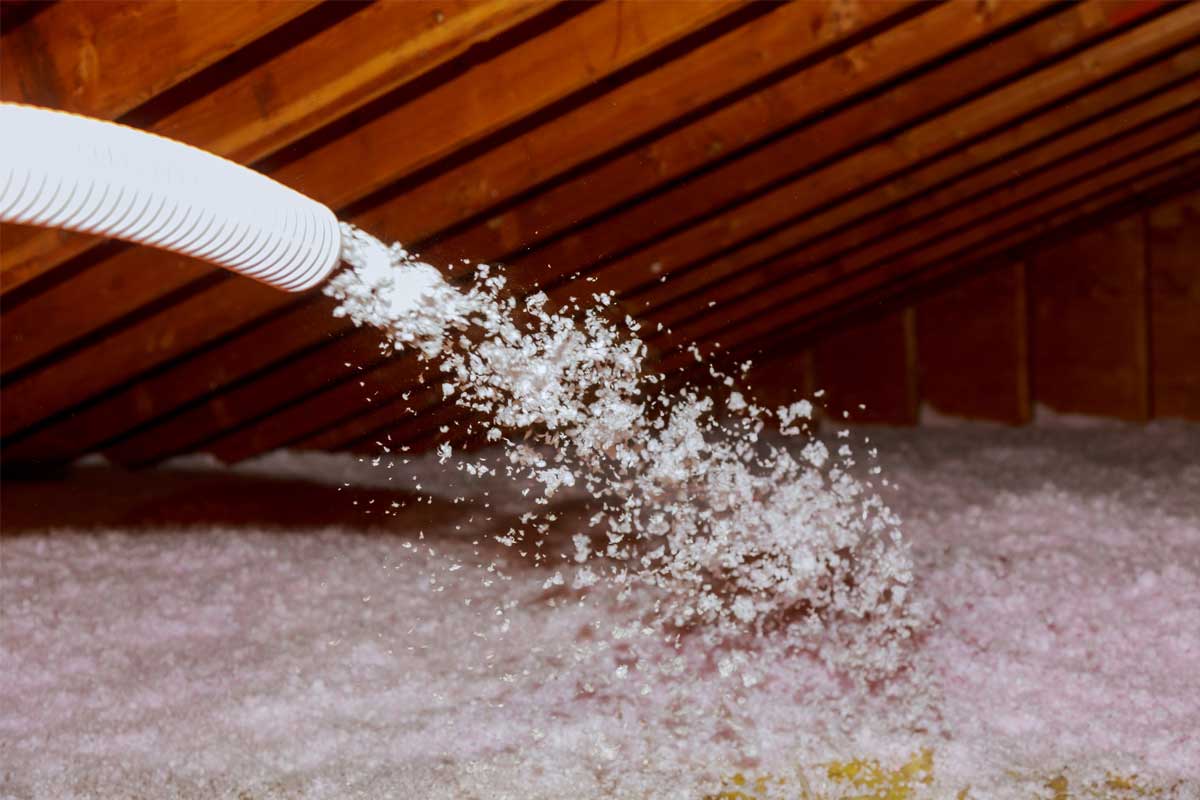 Blown-in insulation being installed in an attic space.