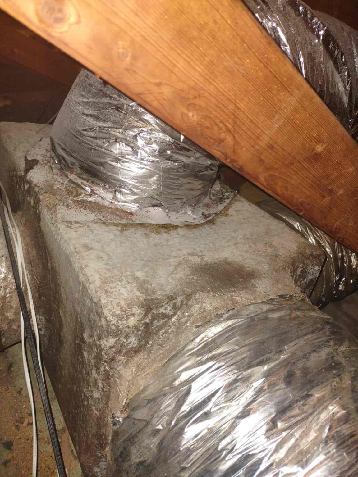 Condensation and moisture buildup on attic ductwork caused by high humidity.