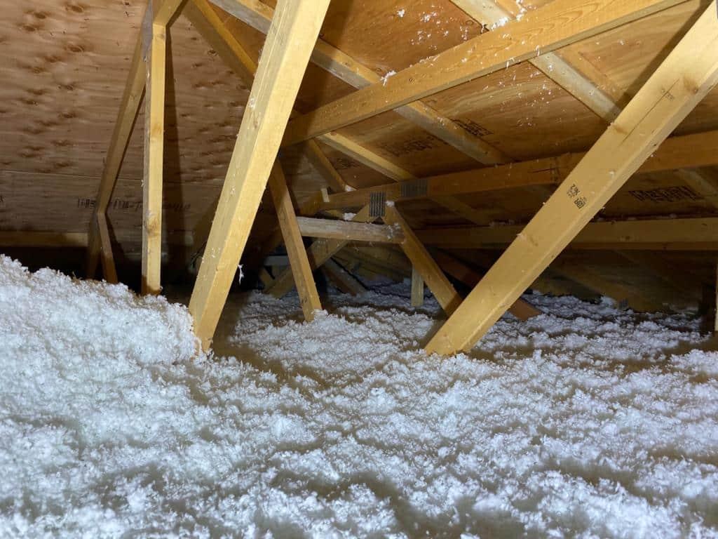 Blown-in insulation covering an attic floor 