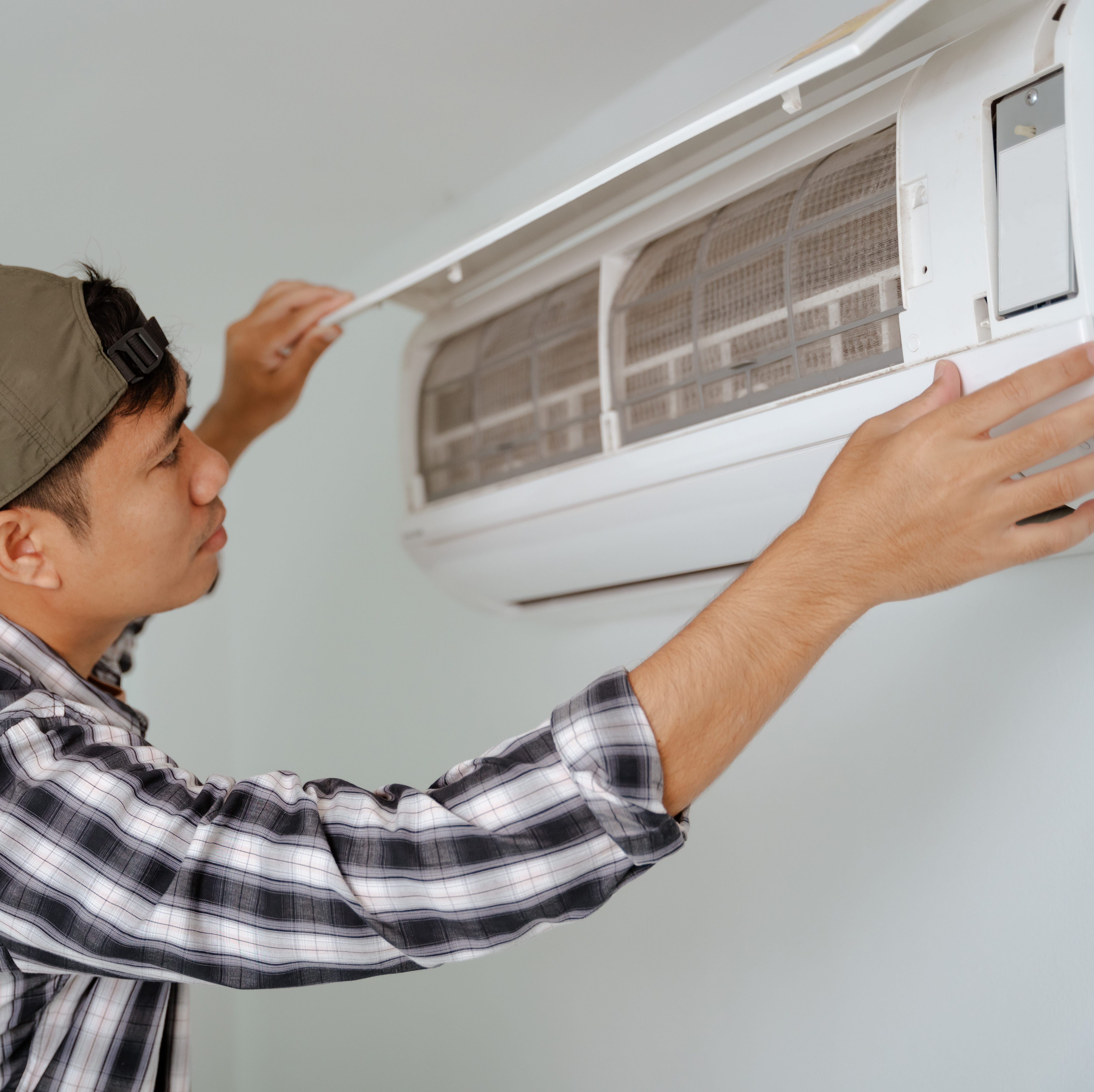 Person replacing an air conditioner filter.