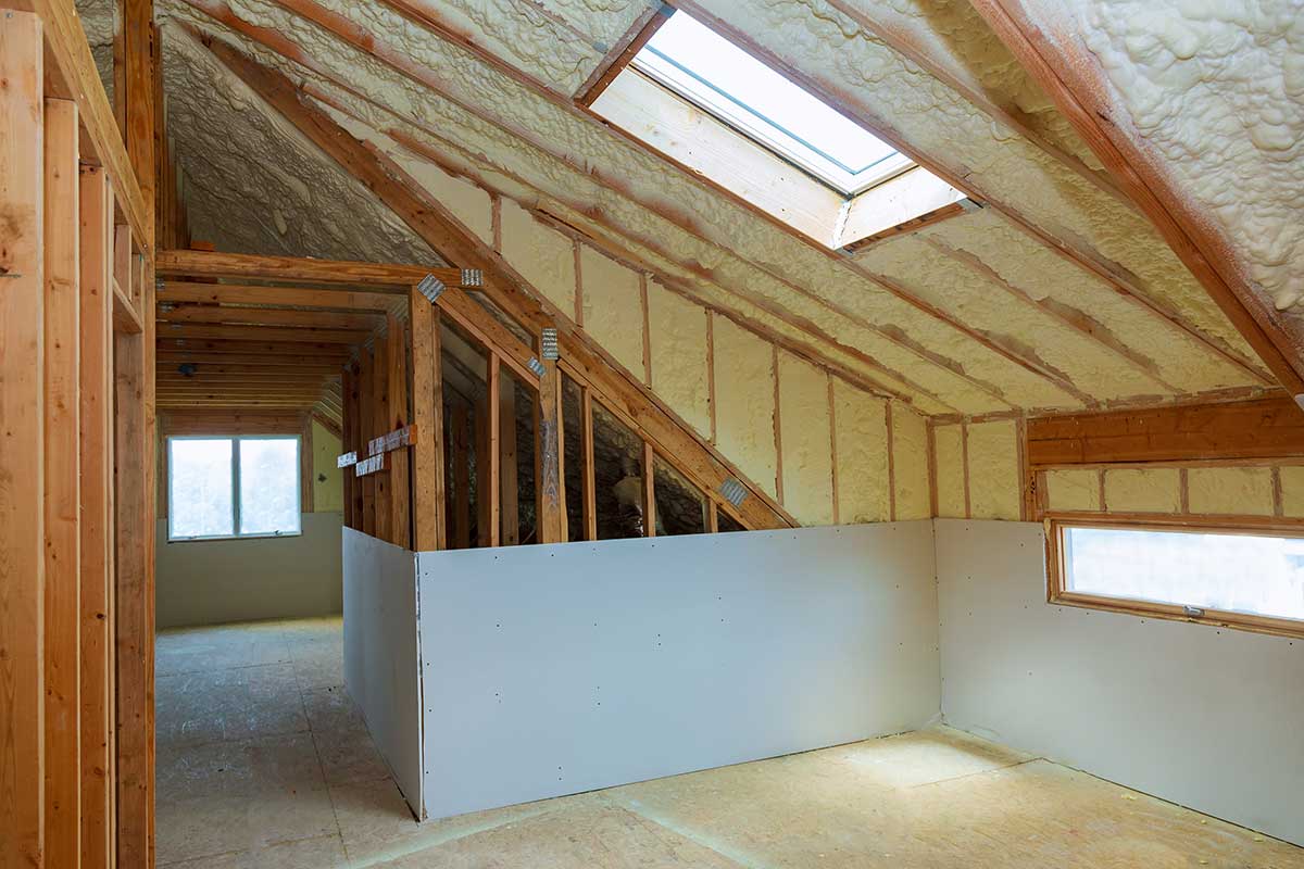 Exposed attic framing with spray foam insulation on the roof deck.